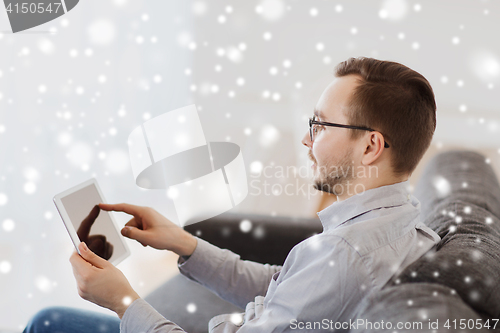 Image of smiling man working with tablet pc at home