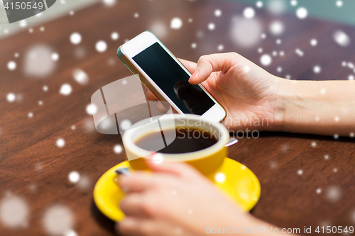 Image of woman with smartphone drinking coffee at cafe