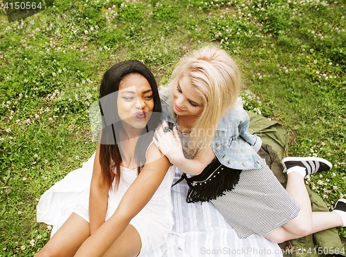 Image of two pretty school girls on grass happy smiling, best friends hav