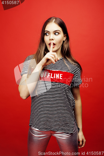 Image of young pretty emitonal posing teenage girl on bright red background, happy smiling lifestyle people concept