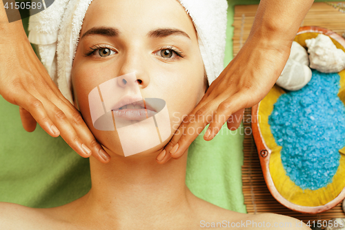 Image of stock photo attractive lady getting spa treatment in salon, close up asian hands on face