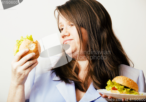 Image of fat white woman having choice between hamburger and salad close 