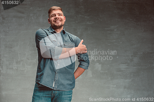 Image of Portrait of smiling happy man standing in studio