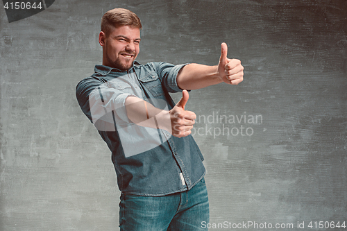 Image of Portrait of smiling happy man standing in studio