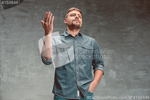Image of Portrait of serious man standing on the chair in studio