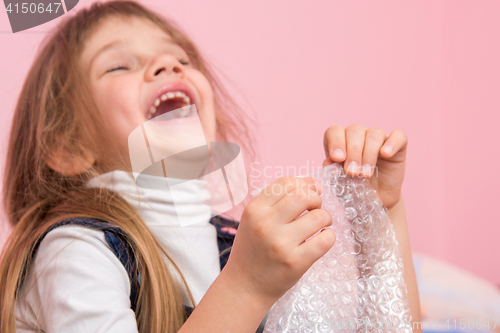 Image of The girl laughs infectiously, playfield balls on the packaging bag