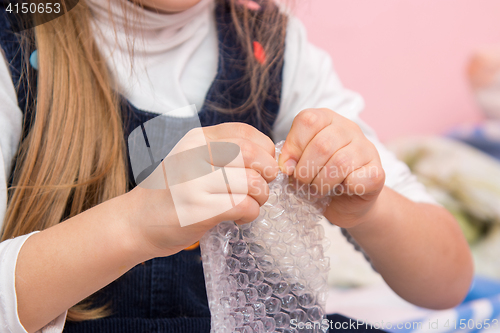 Image of The child eats bubbles on the packaging bag