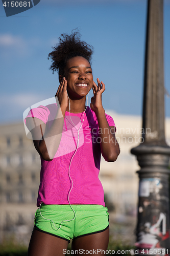 Image of young african american woman running outdoors