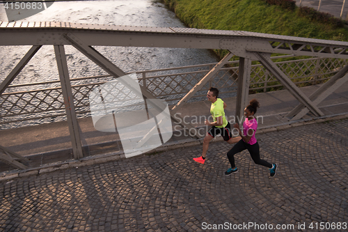 Image of young multiethnic couple jogging in the city