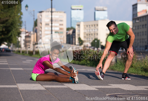 Image of jogging couple warming up and stretching in the city