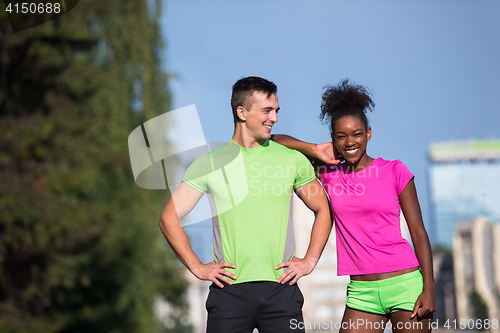 Image of portrait of young multietnic jogging couple ready to run