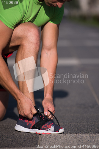 Image of Young athlete, runner tie shoelaces in shoes