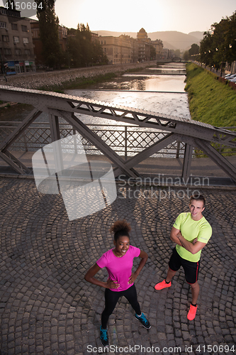 Image of portrait of a young multiethnic couple jogging in the city