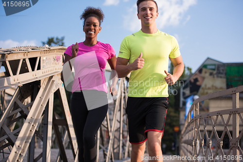 Image of multiethnic couple jogging in the city
