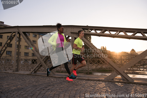 Image of young multiethnic couple jogging in the city