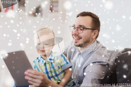 Image of father and son with tablet pc playing at home