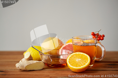 Image of tea with honey, lemon and ginger on wood