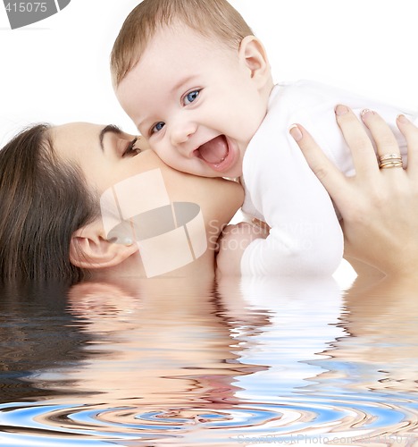 Image of laughing baby playing with mother in water