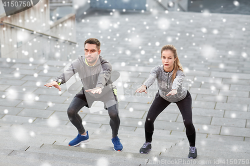 Image of couple of sportsmen doing squats and exercising