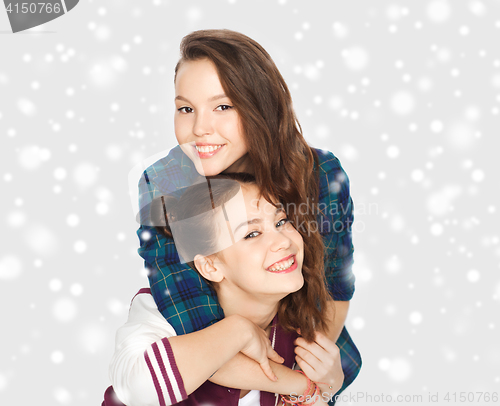 Image of smiling pretty teenage girls hugging over snow