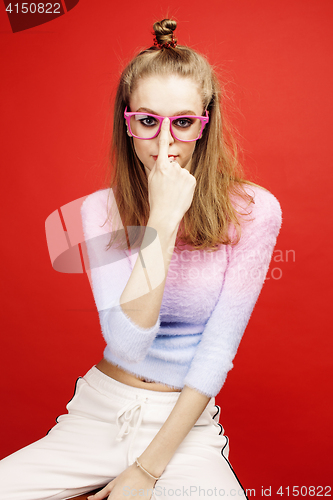 Image of young pretty emitonal posing teenage girl on bright red background, happy smiling lifestyle people concept