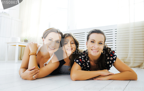 Image of Mature sisters twins at home with little daughter, happy family 