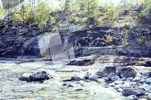 Image of wild north nature landscape. lot of rocks on lake shore