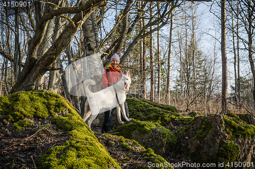 Image of Woman with a white dog in the woods