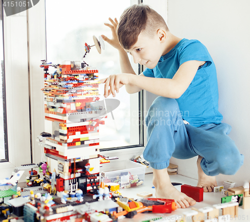 Image of little cute preschooler boy playing lego toys at home happy smiling, lifestyle children concept