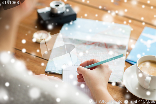 Image of close up of traveler hands with notepad and pencil