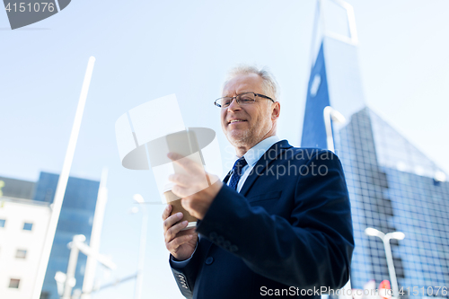 Image of businessman with smartphone and coffee in city