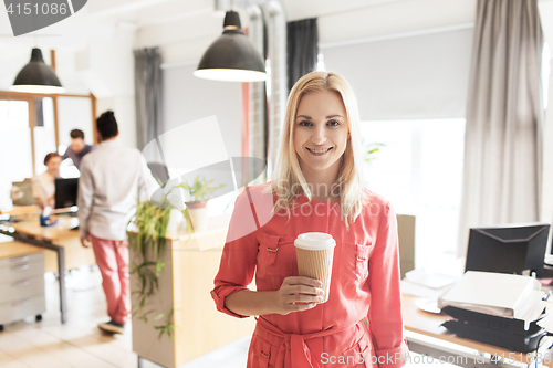 Image of happy creative woman with coffee cup at office