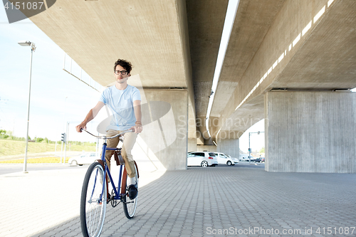 Image of young hipster man riding fixed gear bike