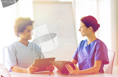 Image of happy doctors with tablet pc meeting at hospital