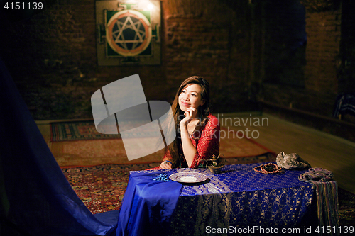 Image of young pretty asian girl in bright colored interior on carpet view