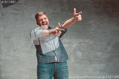 Image of Portrait of smiling happy man standing in studio