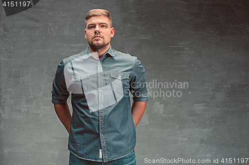 Image of Portrait of serious man standing on the chair in studio