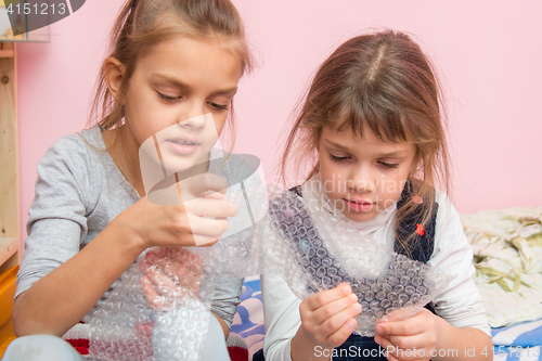 Image of Two girls captivated bubbles burst inflatable packaging package