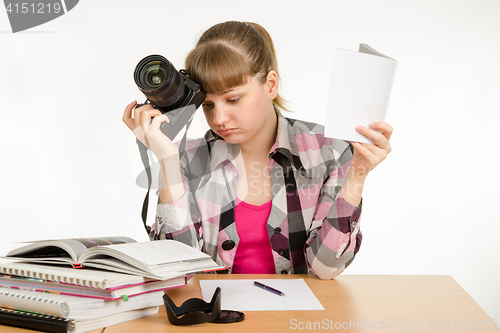 Image of The girl reads the manuals and tutorials, trying to learn how to take pictures