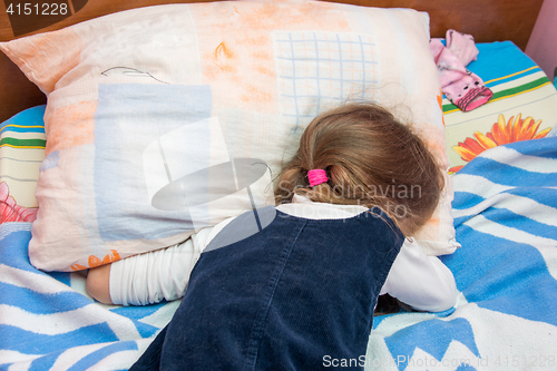 Image of Five-year girl crying with his face buried in the pillow