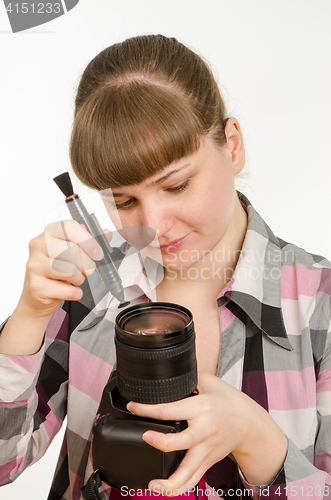 Image of Photographer cleans front of the lens on the camera