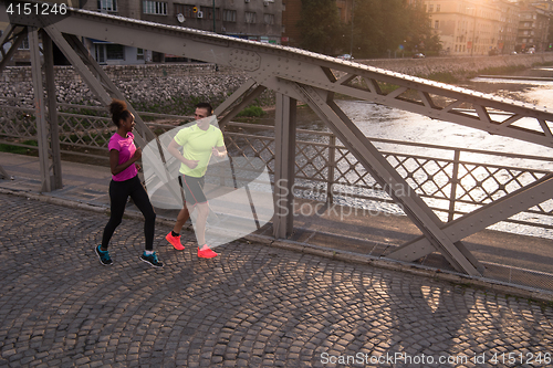 Image of young multiethnic couple jogging in the city
