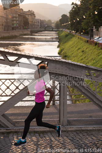 Image of african american woman running across the bridge