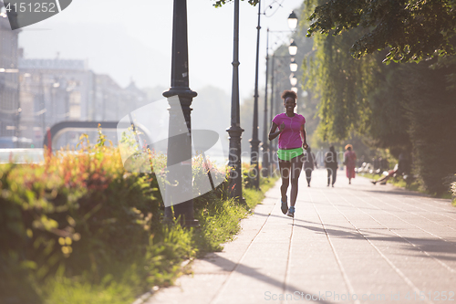 Image of african american woman jogging in the city