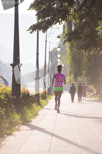 Image of african american woman jogging in the city