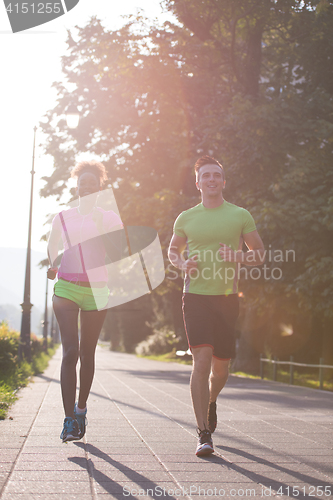 Image of young multiethnic couple jogging in the city