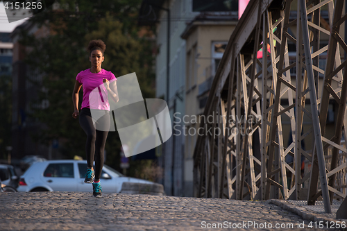 Image of african american woman running across the bridge