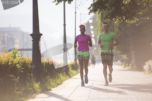 Image of young multiethnic couple jogging in the city