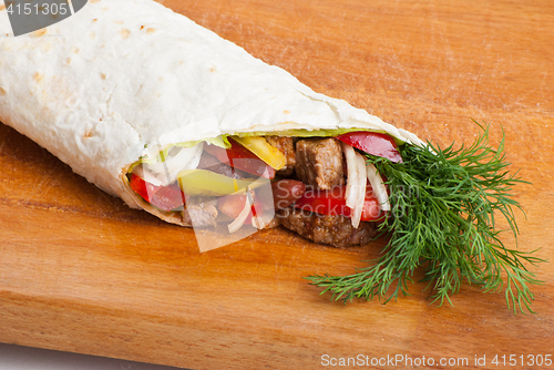 Image of beef burrito with peppers, onion and tomato