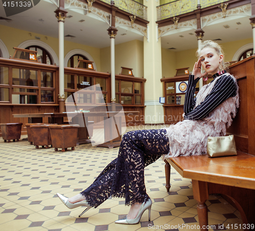 Image of young attractive fashion lady on railway station waiting, vintage people concept in classic interior